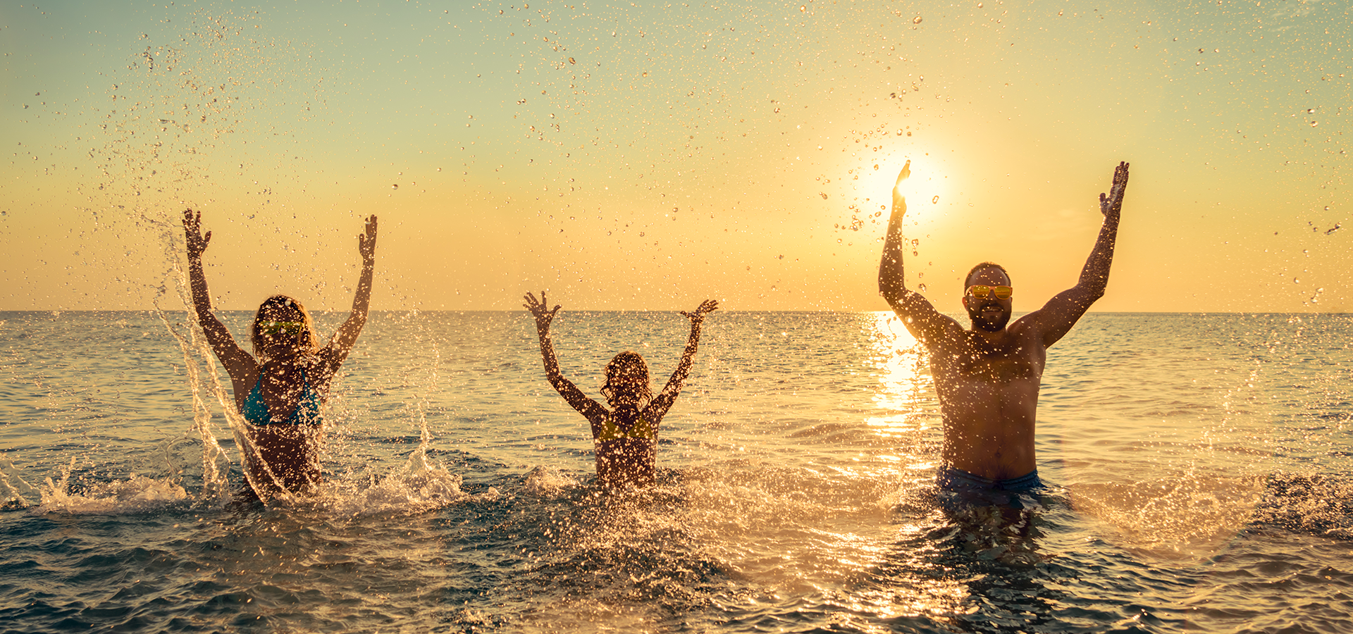 Familie im Wasser am Sunset